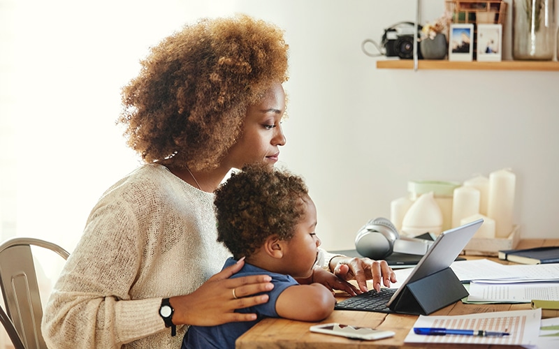 A woman sits with her child as he receives remote rehabilitation for young children