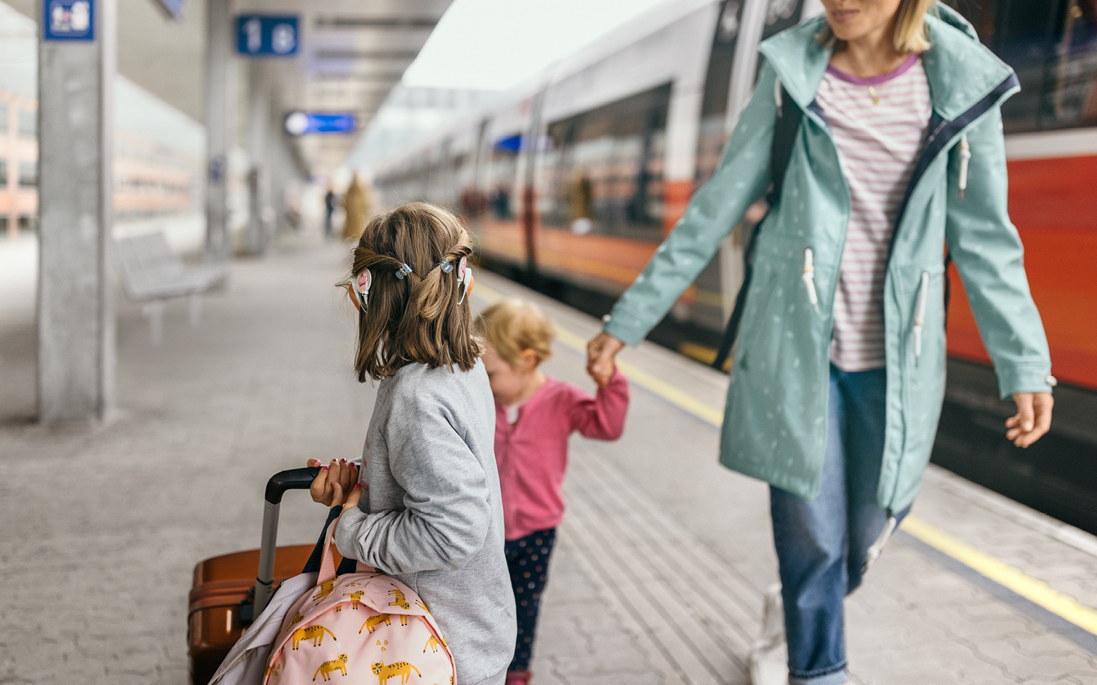 A mother guides her daughter with two SONNET 3's through a train station.