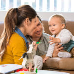 A woman and man speak and play with a very young child. It is important to continue working between therapy sessions with these Strategies to Develop Listening Skills & Speech.