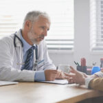 an ENT doctor counsels a patient with balance disorders