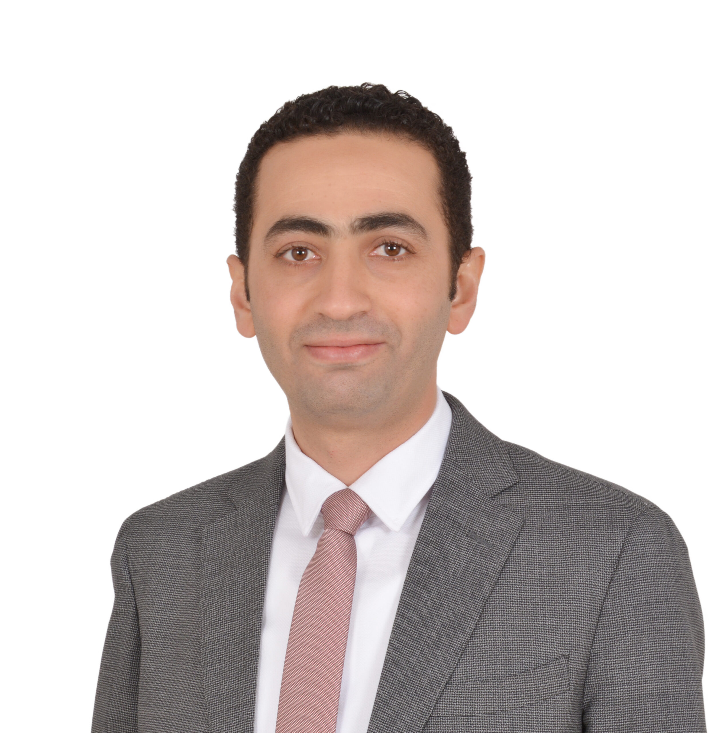 A man wearing a gray suit jacket, white dress shirt, and light pink tie posed against a plain white background in a professional portrait.