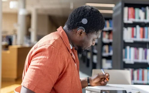 Man with processor is in the library studying