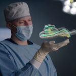 A CI surgeon holds a visualization of a cochlea with the electrode array being inserted.