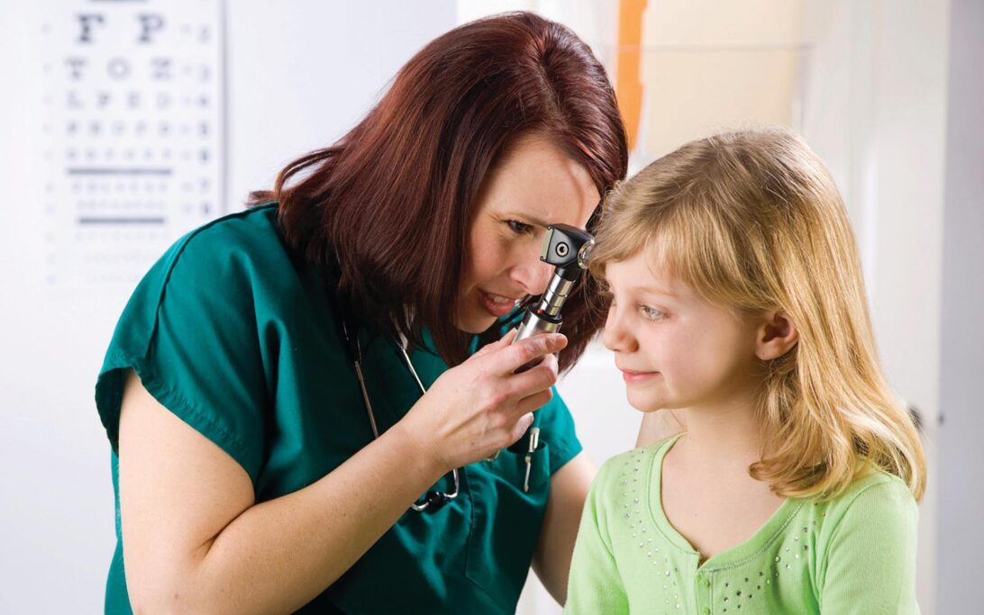 Child having an ear examination with an ENT doctor using an otoscope.