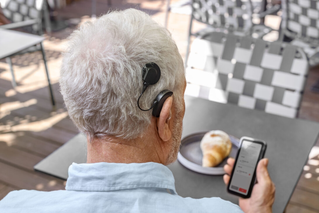 man on phone looking at HearCare app
