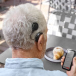 man on phone looking at HearCare app