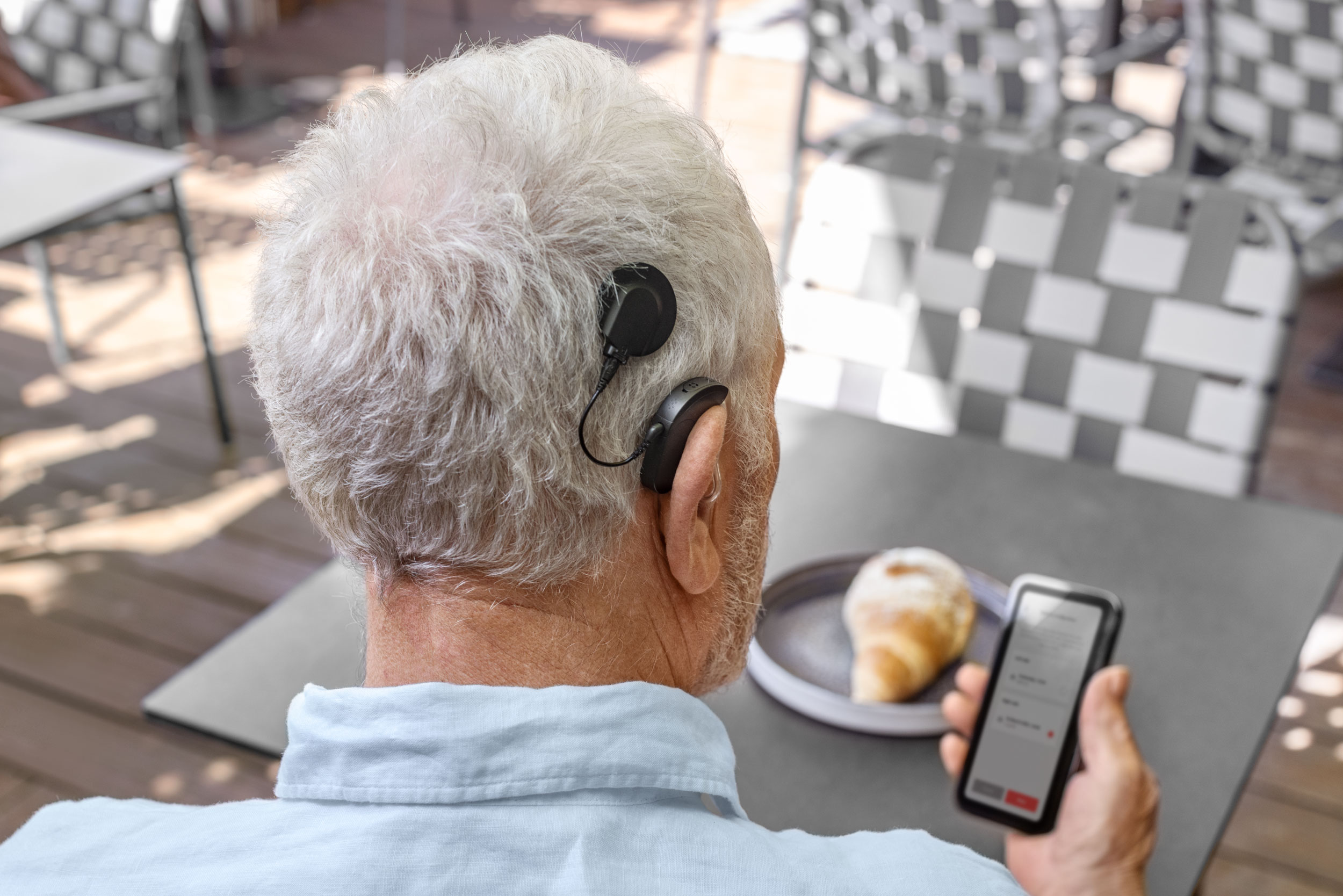 man on phone looking at HearCare app